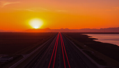 Blurred rays of light from cars passing along the highway at dawn. View from above. Scenery.