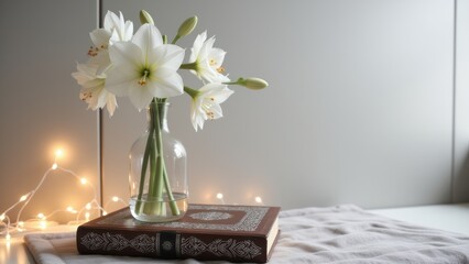 Fototapeta premium White flowers in a glass vase on top of an old book