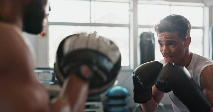 Gym, men and personal trainer with boxer for punch, practice skill and learning with determination for sports. Training, coach and boxing fighter with gloves for fist power, fight exercise or fitness
