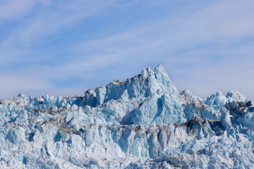 Vast and tall Eqip Glacier (Eqip Sermia) in Greenland north of Ilulissat during sunshine with blue...