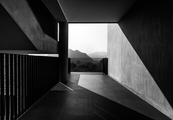 Obraz premium Architecture details of concrete staircase with walkway and mountain background, in black and white light and shadow monotone. 