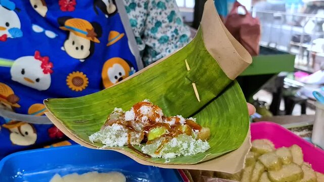 Yogyakarta street food vendor serving fresh Lupis sticky rice cake Lupis is made from sticky rice which is then wrapped in banana leaves