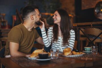 Happy Couple Sharing a Meal in Cozy Cafe Setting