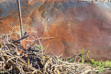 
a pile of branches for a fire place on a metal tin background