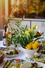 Yellow roses and lemons in glass vase on the wedding table decoration. 