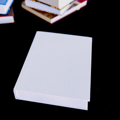 A white book on a black table. Space for text. Book.