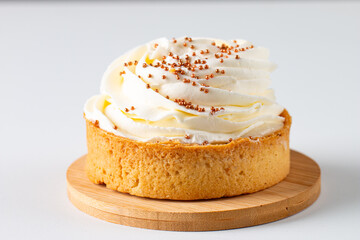 Lemon tartlets with whipped cream, sprinkles and chocolate chips on white background