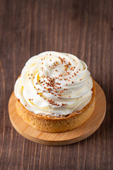 Lemon tartlets with whipped cream, sprinkles and chocolate chips on white background