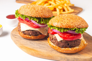 Hamburger made of beef, onion, tomato, lettuce, cheese and spices. Fresh burger closeup. Cheeseburger.