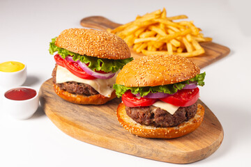 Hamburger made of beef, onion, tomato, lettuce, cheese and spices. Fresh burger closeup. Cheeseburger.