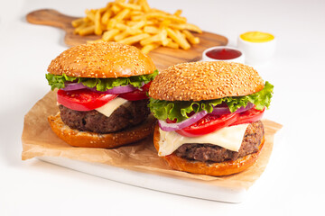 Hamburger made of beef, onion, tomato, lettuce, cheese and spices. Fresh burger closeup. Cheeseburger.