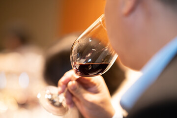 holding glass of red wine