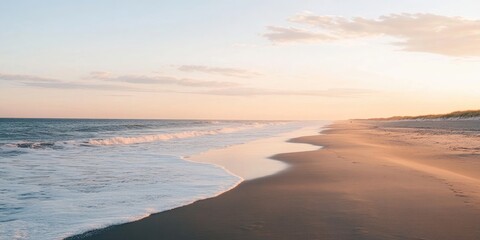 Fototapeta premium Waves gently rolling over the sandy shore during a low tide, just before the sun sets, create a beautiful and serene coastal scene.