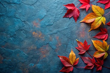 Autumn background with colored red leaves on blue slate background Top view copy space