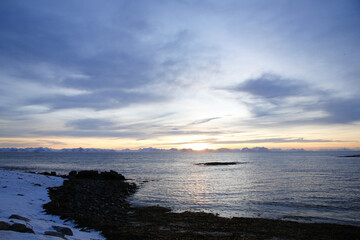 Alba sul villaggio di Andenes, a nord dell'isola di Andoya., con vista sull'isola di Senja. Isole Vesteralen, Norvegia del nord.