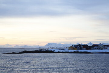 Alba sul villaggio di Andenes, a nord dell'isola di Andoya., con vista sull'isola di Senja. Isole Vesteralen, Norvegia del nord.