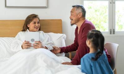 Portrait of happy love asian grandfather with grandmother and asian little cute girl enjoy relax at home.Young girl with their laughing grandparents smiling together.Family and togetherness