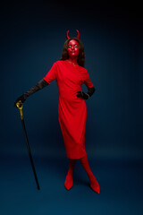 This captivating figure features a striking devil costume in vibrant red tones.