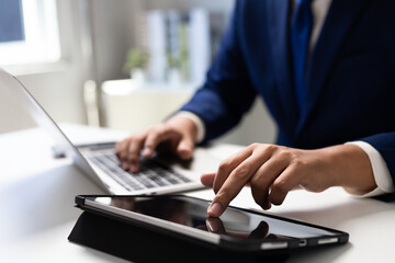 Businessman using laptop and tablet working on tablet at office, Digital work setup, Ideal for remote work and E-learning Concept, Modern workspace for social networking and business management