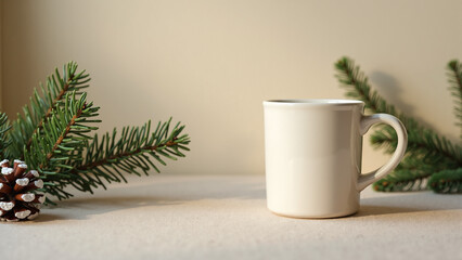 Obraz premium Cozy Christmas scene with holiday mug and pine sprigs on a neutral background