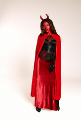 A stunning woman dressed in a red devil costume showcases her creative Halloween spirit with style.