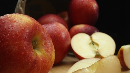 Macrography, slices of fresh apple are arranged on a cutting board against a striking black background. Each close-up shot captures the crisp texture and vibrant colors of the apples. Comestible.