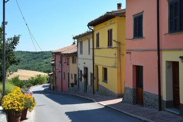 Obraz premium A street in a small Italian village lined with brightly painted houses in various shades of yellow, pink, and orange.