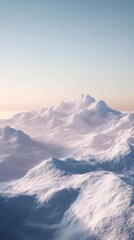 Fototapeta premium Snow-capped mountain peaks under a clear sky at dawn, soft light creating gentle shadows