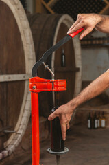 close-up of a man corking a bottle of wine at a winery