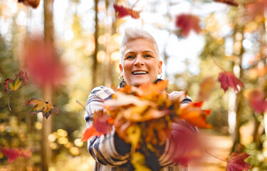 Mature woman in autumn forest, dressed in cozy fall attire, Reflection and connection with nature,...