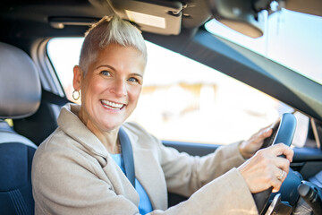 Happy owner. Handsome mature woman sitting relaxed in his newly bought car.