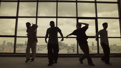 Silhouette shot of skilled choreographer group dancing together with sky scrapper, cityscape background. Young hipster team dancing performance. Sepia filter. Shadow. Outdoor sport 2024. Hiphop.