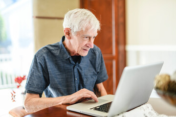 men senior in front of laptop at home