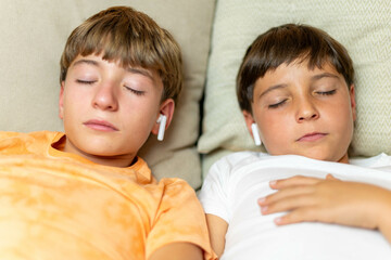 Close-up portrait of two relaxed children sleeping with headphones