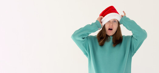 Woman with a christmas hat pulled over her eyes looking with one eye at camera