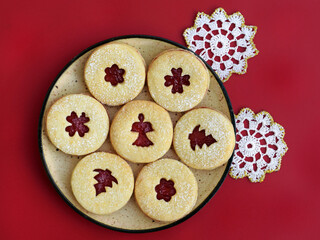 Linzer cookies on a plate, with romantic decoration on red background
