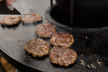 Sizzling, Mouthwatering Burgers Cooking Perfectly on a Griddle at a Summer BBQ Event