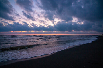 A blurry picture of a beautiful beach at sunset with clouds