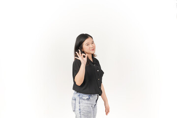 beautiful Asian woman smiles warmly while making an 'OK' hand gesture against a bright white...