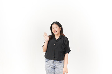 beautiful Asian woman smiles warmly while making a friendly 'hi' hand gesture against a white background