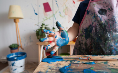 Obraz premium Childs Hand Covered in Blue Paint Art Supplies