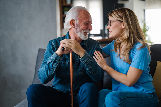 Elderly Man and Young Woman Sharing a Joyful Moment on Sofa
