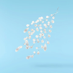 Christmas holliday image, Christmas bauble in shape of a icicle falling in the air isolated on blue background
