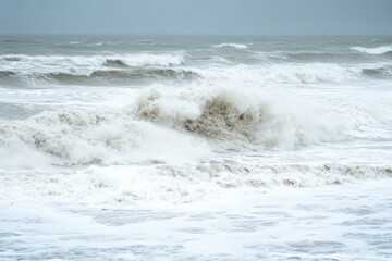 Fototapeta premium This striking image depicts high waves risen and crashing on an expansive ocean surface, showcasing the raw, untamed power of the sea during stormy weather.