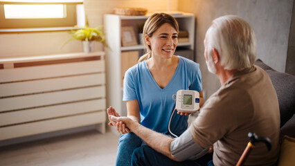 Home Care Nurse Checking Elderly Man's Blood Pressure