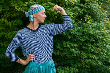 Beautiful young positive female cancer patient wearing headscarf outdoors portrait. Mental health,...