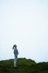 Woman standing in the middle of a cliff in a foggy day