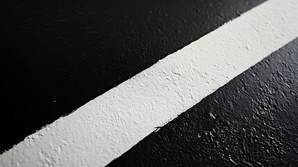 A close-up of a smooth black surface interrupted by a bold white stripe running horizontally across the center, conveying modern minimalism