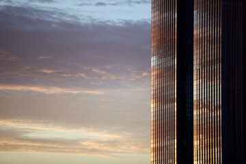 Glass surface of city skyscraper facades in the morning light. Commercial real estate. Modern business city district. Office buildings exterior closeup. Financial city district. Downtown.