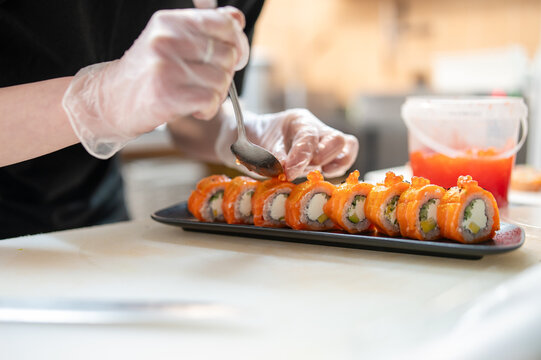 professional chef's hands making sushi roll in a restaurant kitchen
